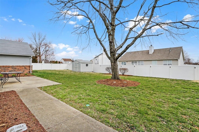 view of yard with a storage shed, a fenced backyard, a residential view, an outdoor structure, and a patio area