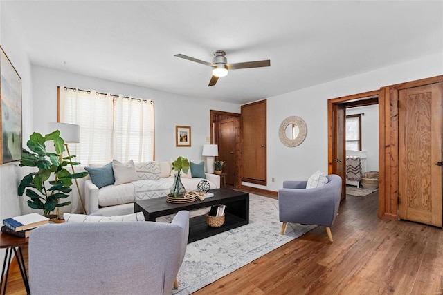 living room with a ceiling fan, a wealth of natural light, and light wood finished floors