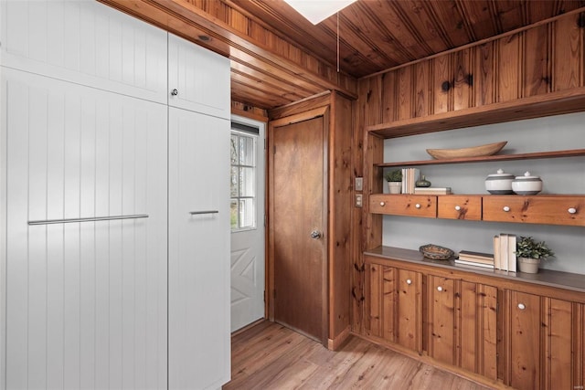 kitchen with wooden walls, wooden ceiling, light wood-style flooring, and open shelves