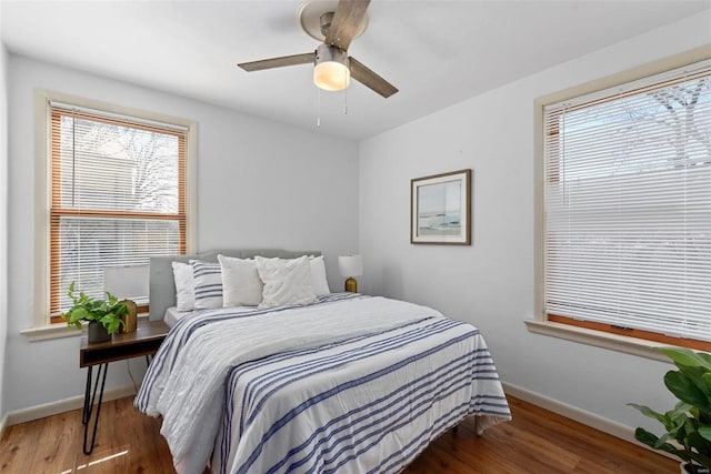 bedroom featuring ceiling fan, baseboards, and wood finished floors