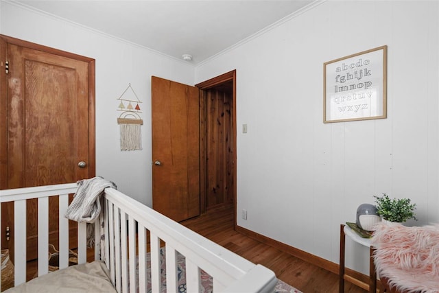 hallway featuring crown molding, baseboards, wood finished floors, and an upstairs landing