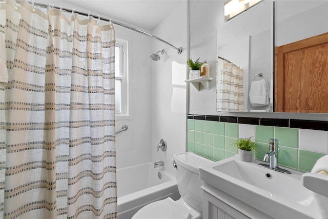 full bath with toilet, vanity, tile walls, and shower / tub combo with curtain