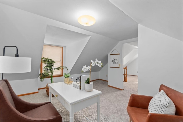 office featuring lofted ceiling, baseboards, and light colored carpet