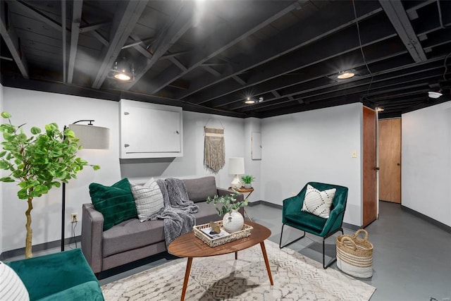 living area featuring concrete floors and baseboards