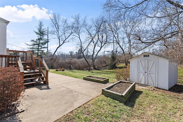 view of yard featuring a deck, an outdoor structure, a garden, a storage unit, and a patio area