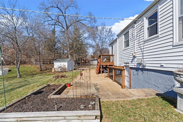 view of yard with a garden, a storage unit, and an outbuilding