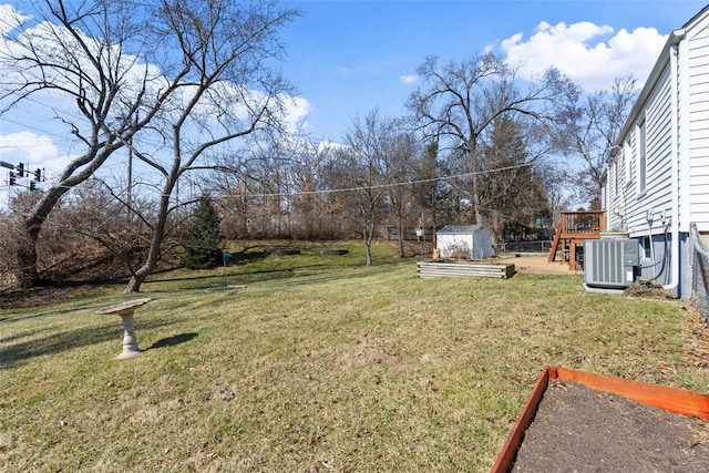 view of yard with central air condition unit, a storage shed, and an outbuilding