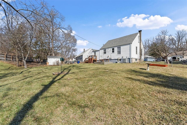 view of yard with a storage shed, an outdoor structure, and fence