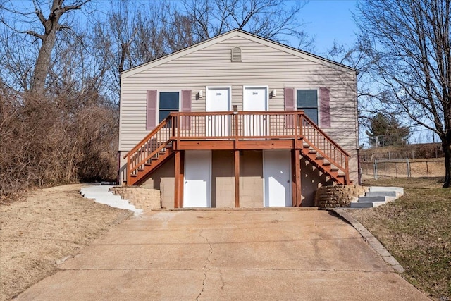 view of front of home featuring driveway, stairs, and fence