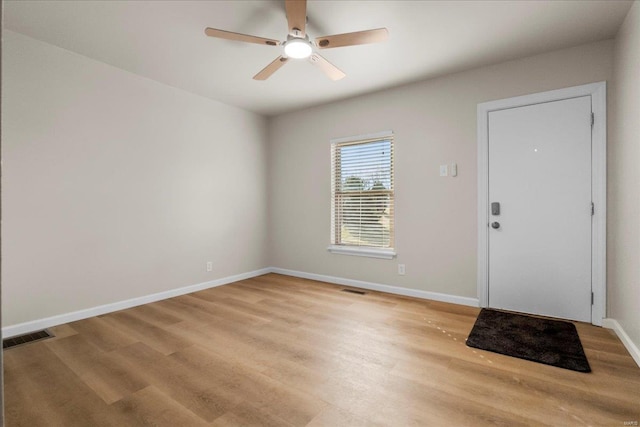 entryway featuring light wood-type flooring, ceiling fan, visible vents, and baseboards