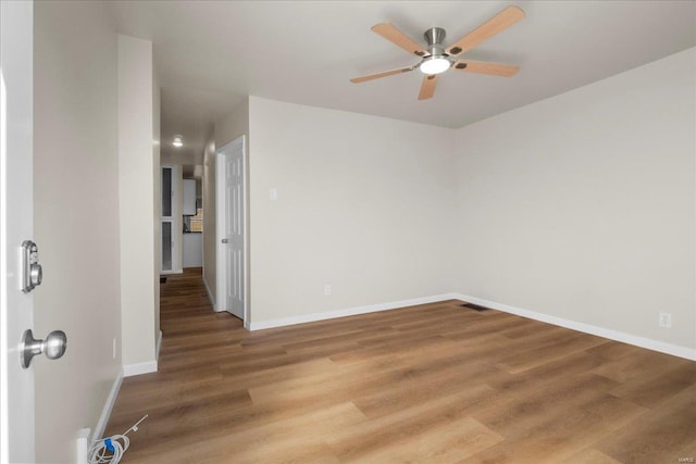 unfurnished room featuring baseboards, ceiling fan, and light wood finished floors