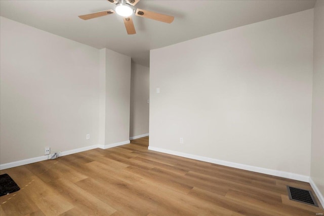 unfurnished room featuring a ceiling fan, light wood-style flooring, visible vents, and baseboards