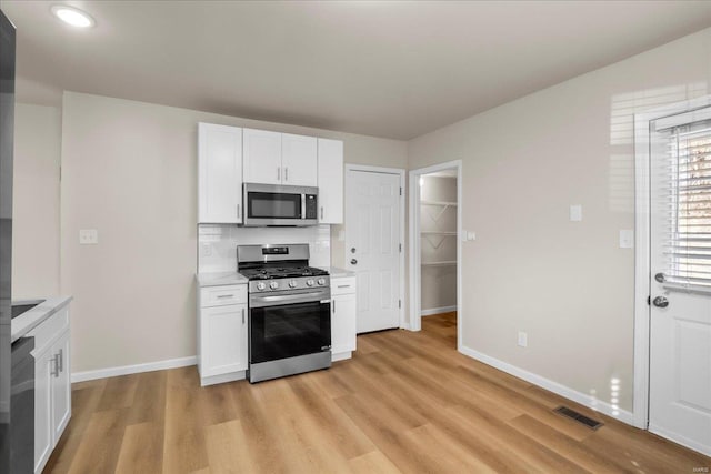 kitchen with white cabinetry, visible vents, appliances with stainless steel finishes, and light countertops