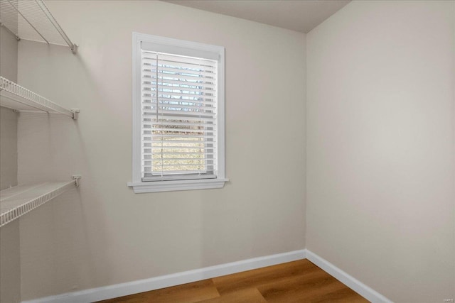 walk in closet with wood finished floors