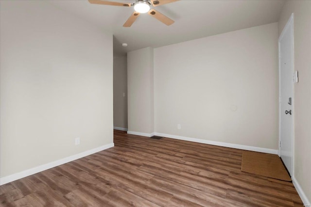 unfurnished room featuring ceiling fan, visible vents, baseboards, and wood finished floors