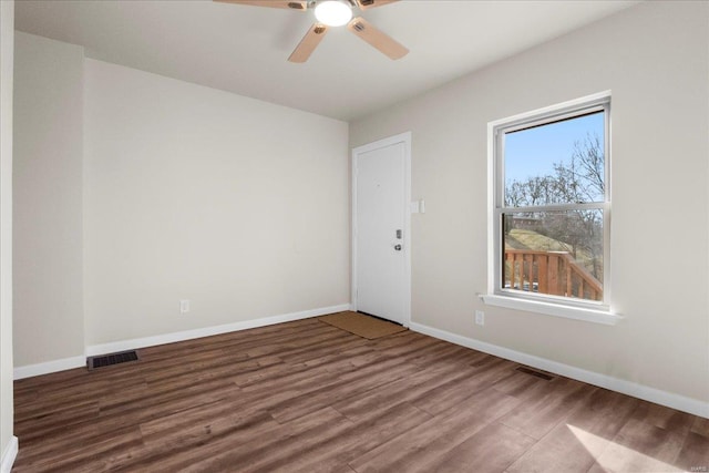 spare room featuring baseboards, visible vents, and wood finished floors