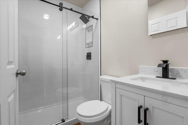 full bath with vanity, a shower stall, and toilet