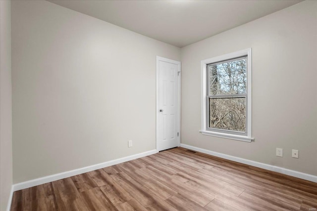 empty room with baseboards and wood finished floors