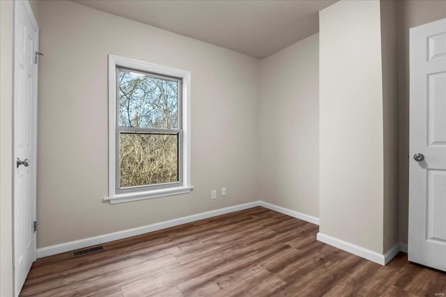 unfurnished bedroom featuring wood finished floors, visible vents, and baseboards