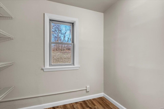 interior space with a wealth of natural light, baseboards, and wood finished floors