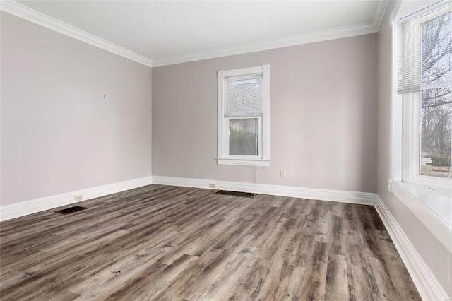 unfurnished room with baseboards, crown molding, visible vents, and wood finished floors