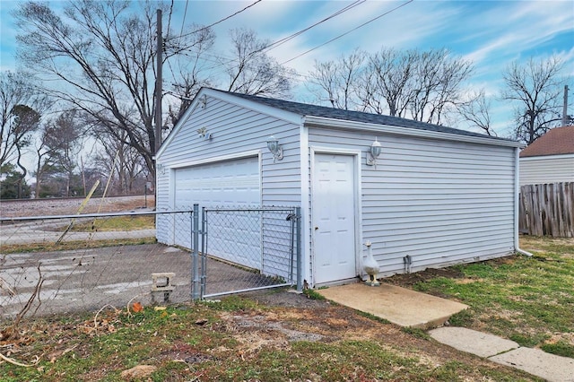 detached garage with a gate and fence