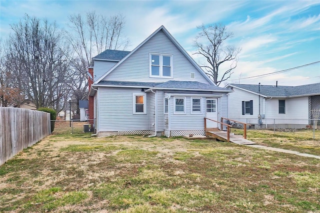 rear view of house featuring a shingled roof, central AC, a yard, and a fenced backyard