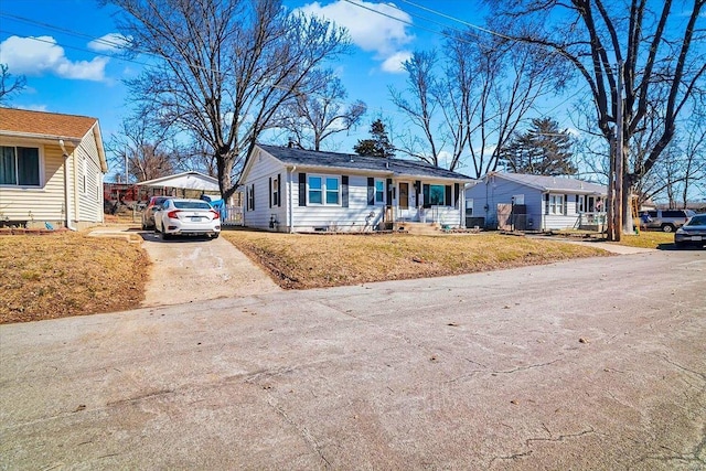 ranch-style home featuring concrete driveway, a porch, crawl space, and a front yard