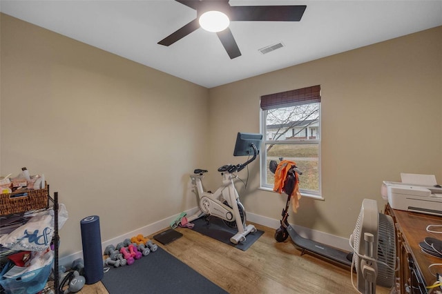 workout area featuring a ceiling fan, wood finished floors, visible vents, and baseboards