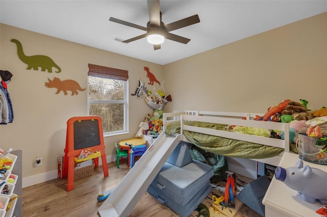 bedroom featuring visible vents, ceiling fan, baseboards, and wood finished floors