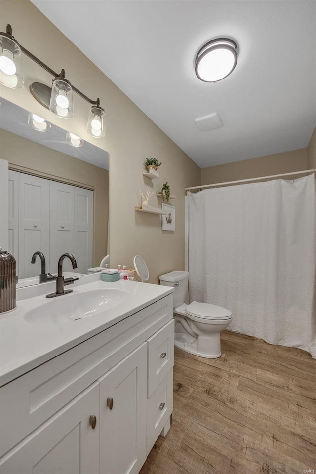 full bath with vanity, toilet, and wood finished floors