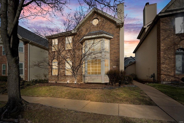 view of front of home with a front lawn and brick siding