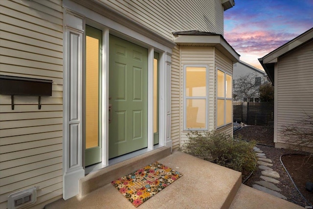 exterior entry at dusk with visible vents and fence