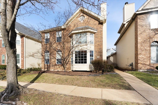 view of front facade featuring brick siding and a front lawn