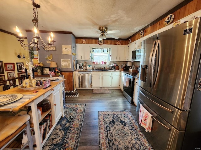 kitchen with a textured ceiling, appliances with stainless steel finishes, dark wood-style flooring, and white cabinetry