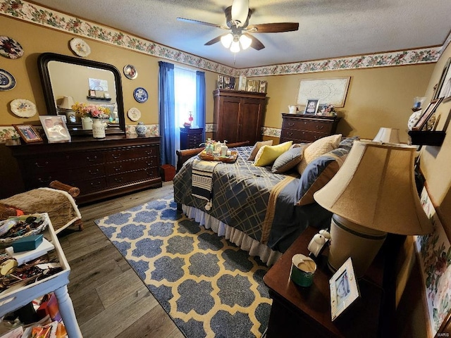 bedroom featuring a textured ceiling, ceiling fan, and light wood-style flooring