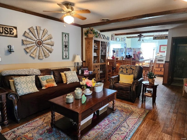 living area with a ceiling fan, crown molding, beamed ceiling, and wood finished floors