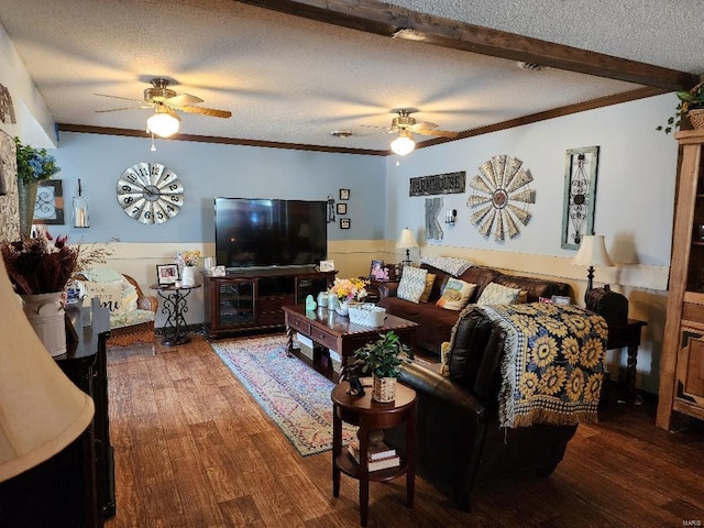 living room with ceiling fan, ornamental molding, beamed ceiling, wood finished floors, and a textured ceiling