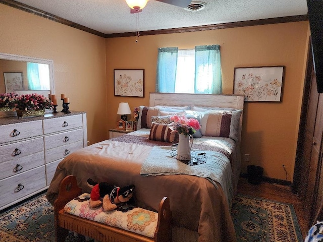 bedroom featuring a textured ceiling, visible vents, and crown molding