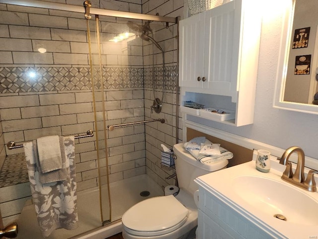 bathroom with toilet, a shower stall, and vanity