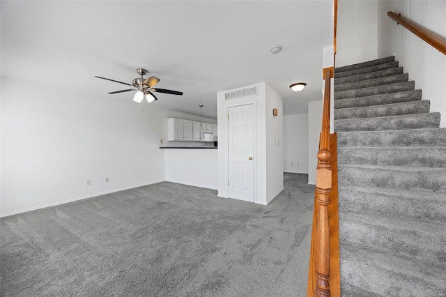 unfurnished living room with carpet, stairs, visible vents, and ceiling fan