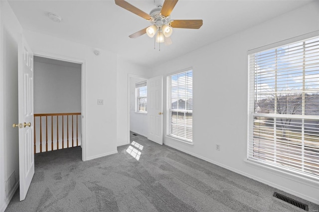 unfurnished bedroom featuring ceiling fan, carpet flooring, visible vents, and baseboards