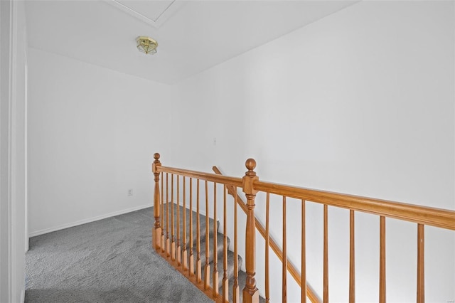 hallway featuring baseboards, carpet flooring, and an upstairs landing