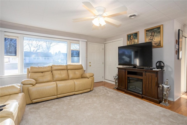 living room featuring a ceiling fan, visible vents, and wood finished floors