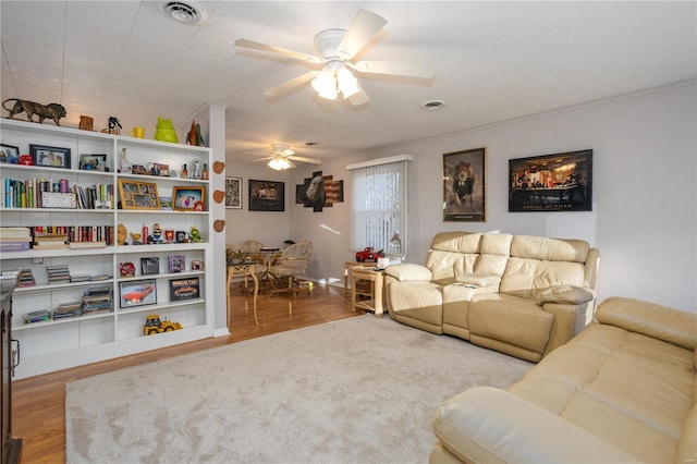 living room with ceiling fan, wood finished floors, and visible vents