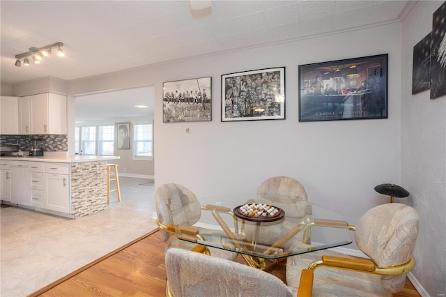 dining space featuring light wood finished floors and baseboards