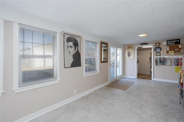 foyer entrance with concrete flooring and baseboards