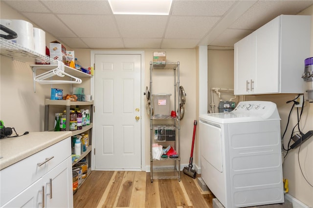 washroom with light wood-style flooring, cabinet space, and washer / dryer