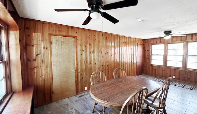 dining room with wood walls and visible vents