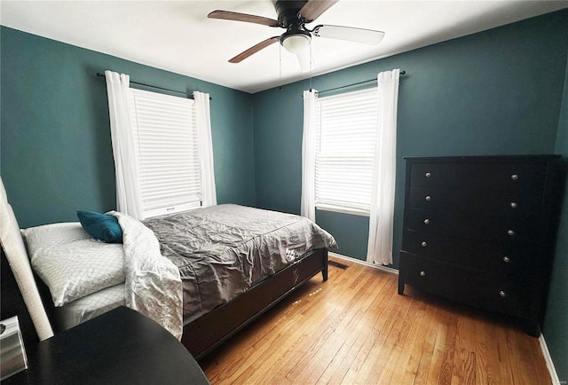 bedroom with ceiling fan, light wood-type flooring, and baseboards